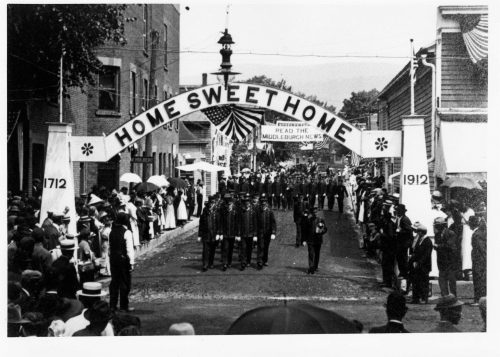 Home week Parade 1912. Sign says "Home Sweet Home" is in between a podium that says 1712 to the left and a podium that says 1912 to the right.