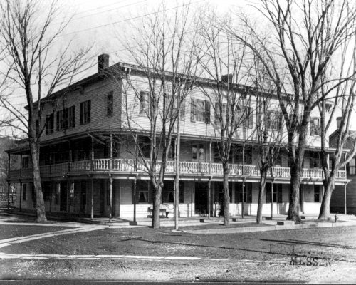 Large three story hotel with a balcony.