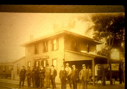 Eleven people standing in front of a building.