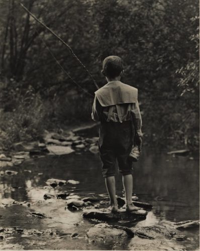 Boy standing on rock fishing.