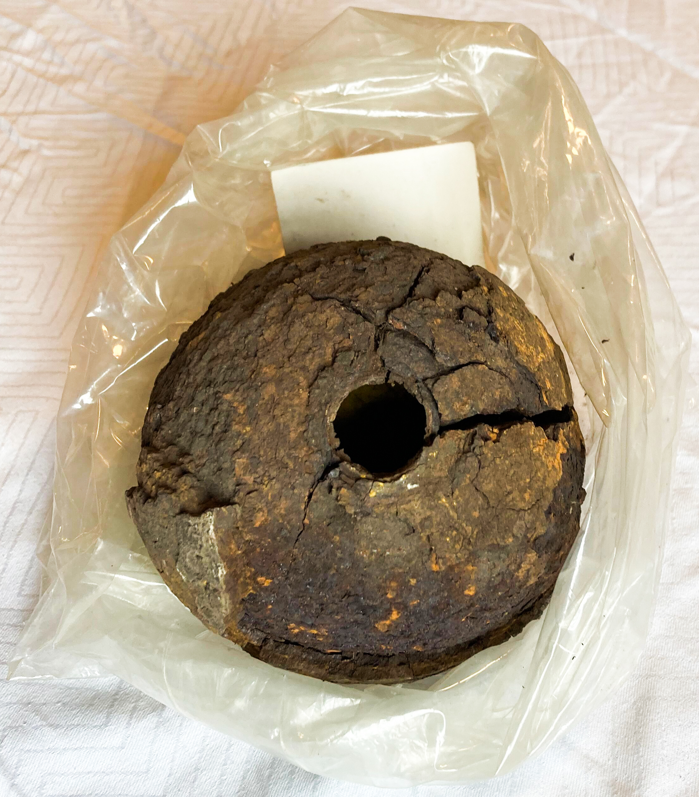 Cracked mortal shell in bag with large ammunition hole. 