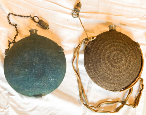 Two canteens, one blue with no strap, one brown with strap and bullseye pattern