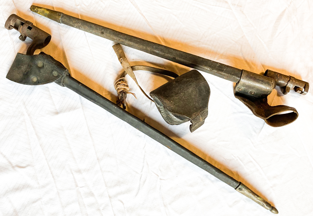 Two bayonets in their scabbards with a cap box in between them.