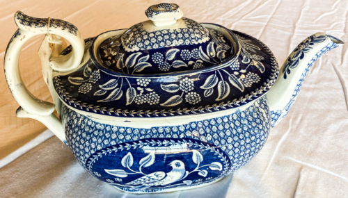 Blue and white pattern teapot with flowers and a bird.