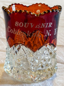 Red and clear shot glass with words "Souvenir, Cobleskill, N.Y."