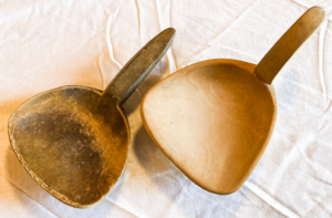 Two wooden butter ladles.