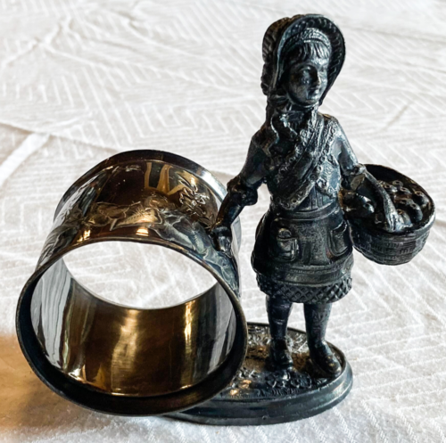 Napkin holder with figurine of girl holding basket.