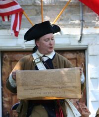 Jeff O'Connor dressed in colonial clothing reading the Declaration of Independence.