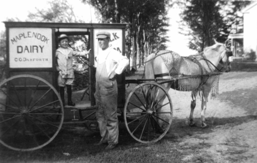 Clifford with son near horse drawn milk carriage.