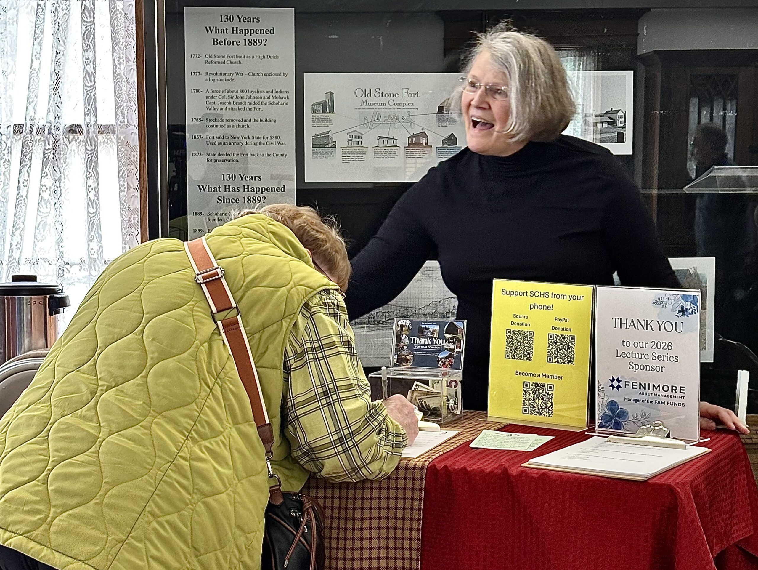 Volunteer greeting people at the door.