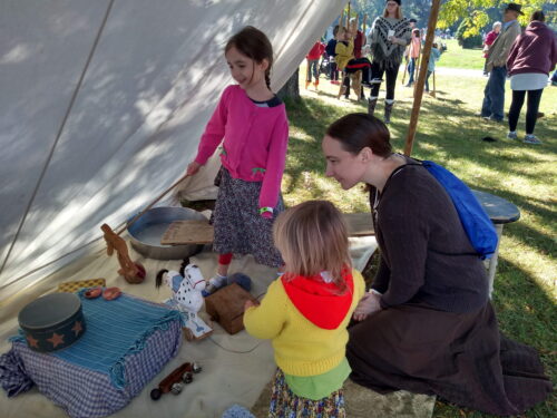 A mother with her two kids looking at artifacts.