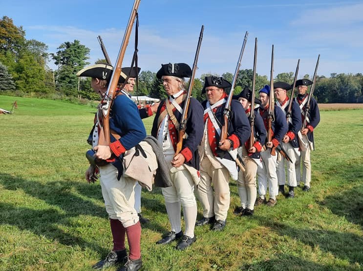 Revolutionary War re-enactors in line formation.