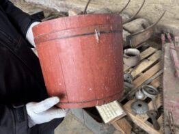 Person showing off a bucket in the collection.
