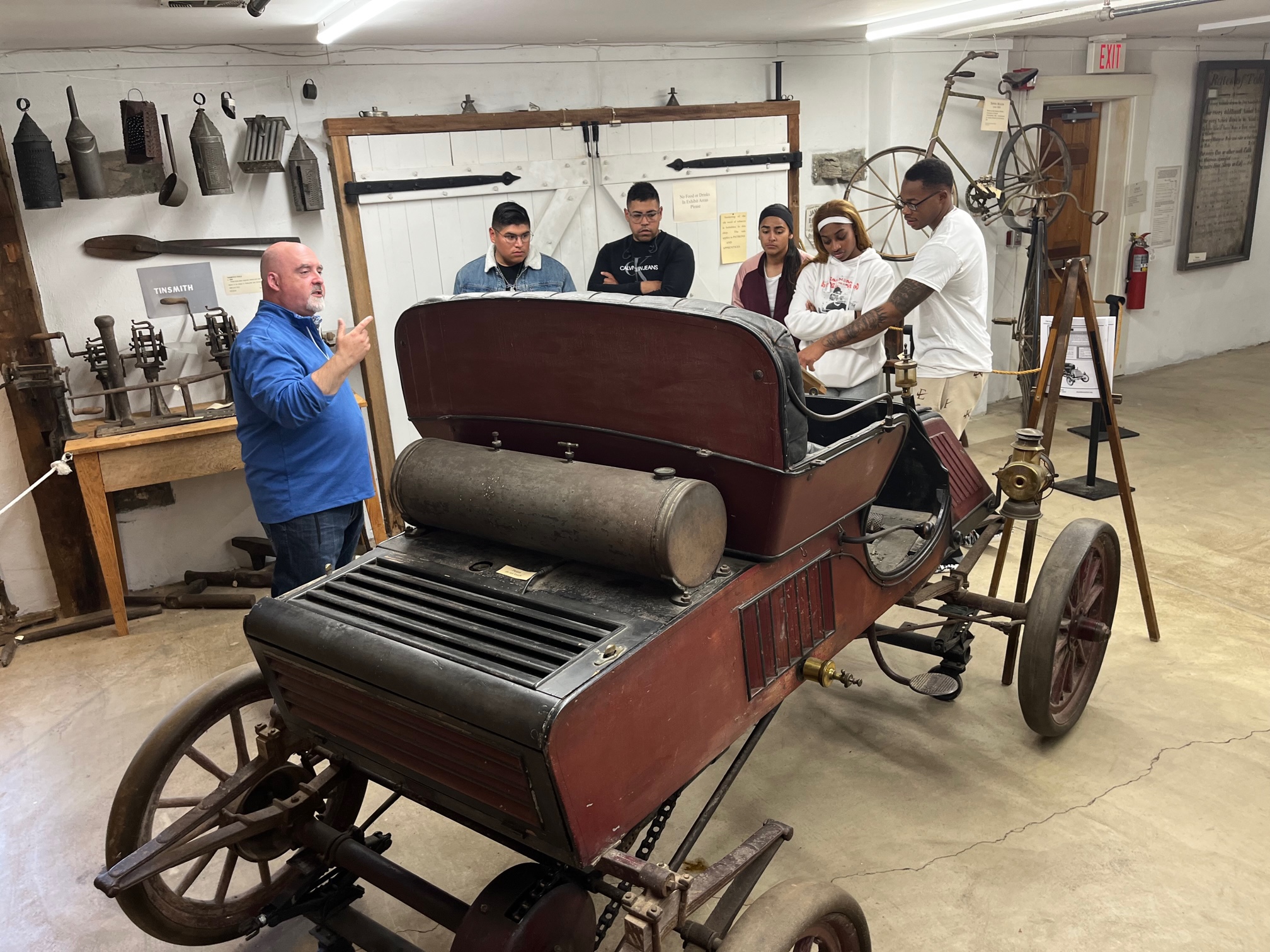 Curator giving a tour showing off the Rambler automobile.