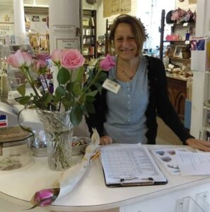 Woman smiling while working at our admissions desk.