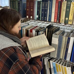 Looking through a book in the stacks.