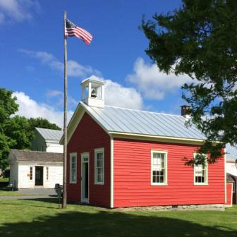 red schoolhouse with flag pole